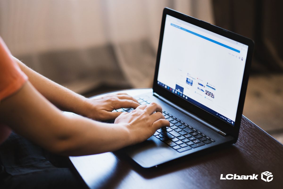 Uma pessoa digitando em notebook simulando a consulta